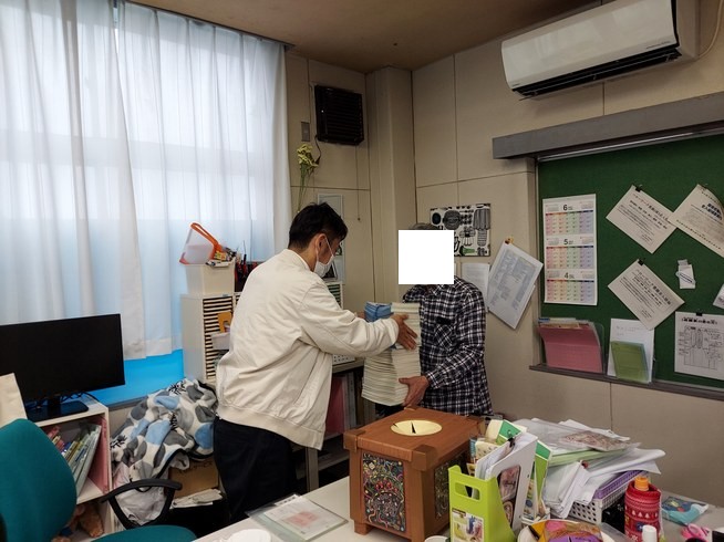 いままで取り組まれた公文のたくさんの問題用紙を社長から授与される写真